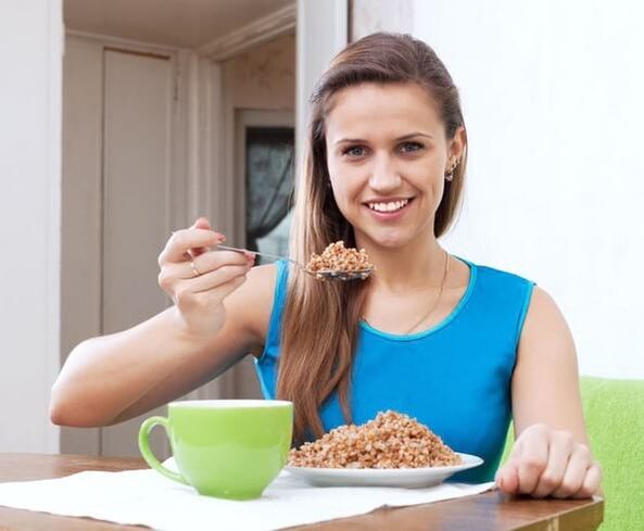 The girl eats buckwheat for weight loss